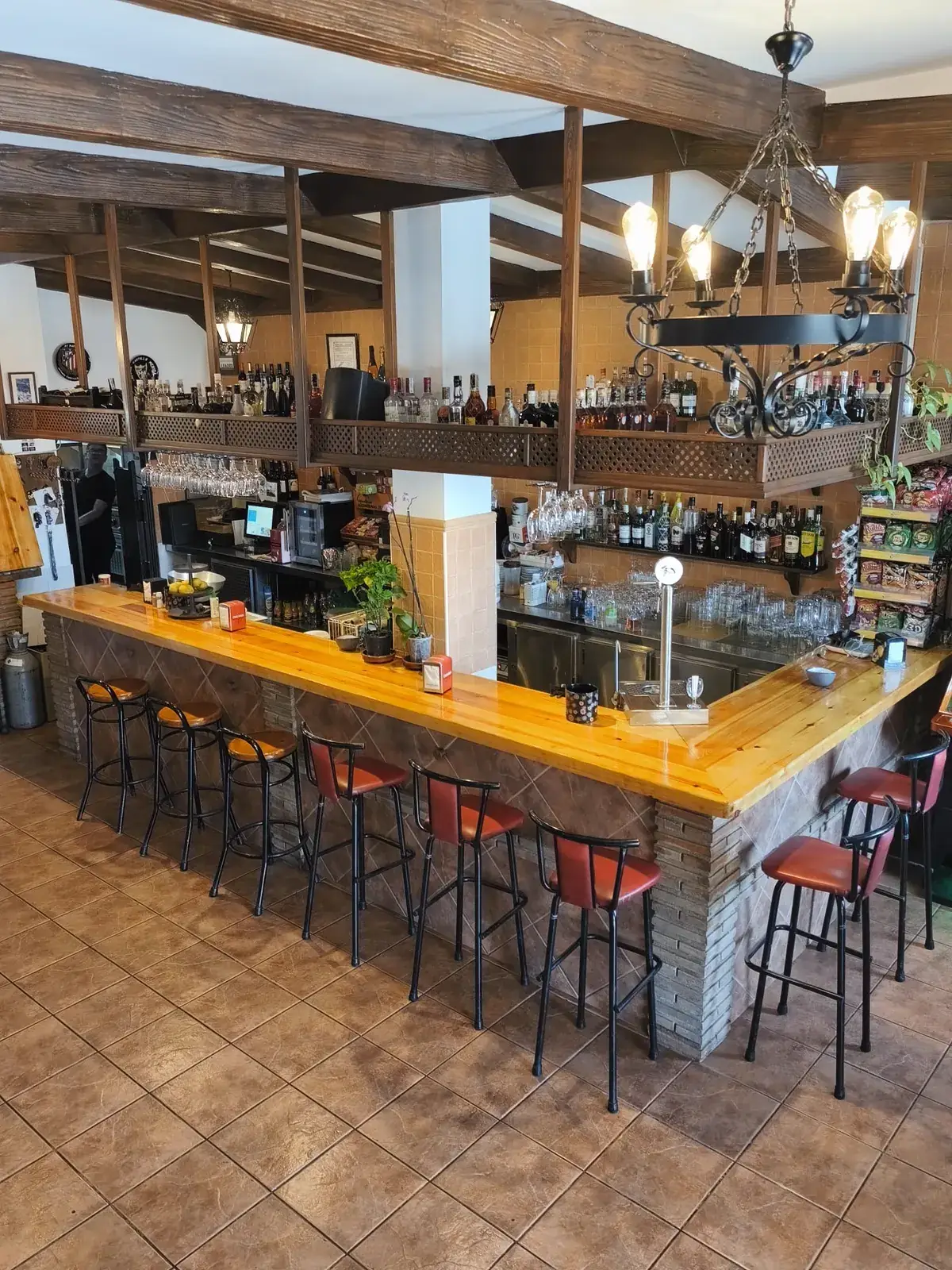 Interior del mesón: barra, vigas de madera y mesas
